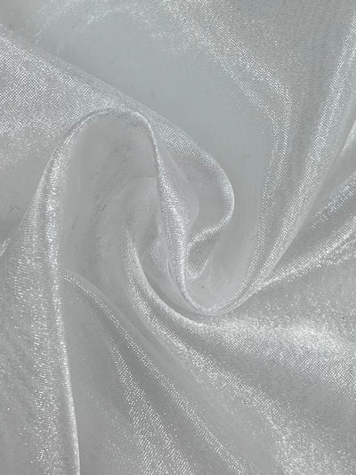 Close-up of Super Cheap Fabrics' Organza - White - 150cm, softly gathered into gentle folds and swirls. This lightweight fabric offers a smooth, reflective texture for an elegant and delicate look.