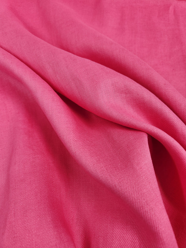 The Pure Washed Linen - Hot Pink - 140cm by Super Cheap Fabrics features a bright hot pink fabric with a smooth, slightly textured surface that elegantly drapes in soft folds. This lightweight material highlights and shadows subtly as it catches the light, enhancing the depth of its vibrant color.