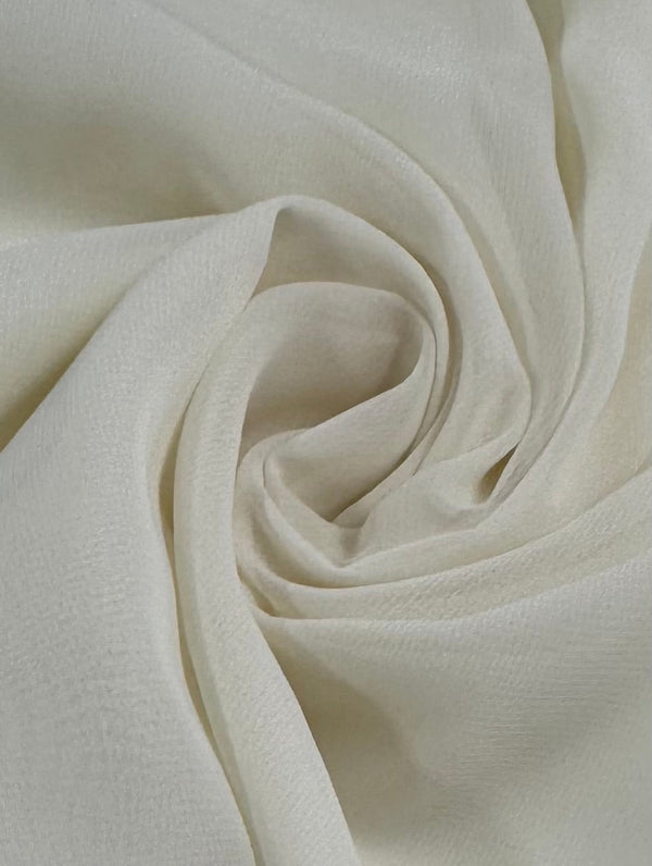 A close-up of Super Cheap Fabrics' Hi-Multi Chiffon in Cream (148cm) shows its soft, lightweight texture arranged in gentle, swirling folds for a beautiful spiral effect.