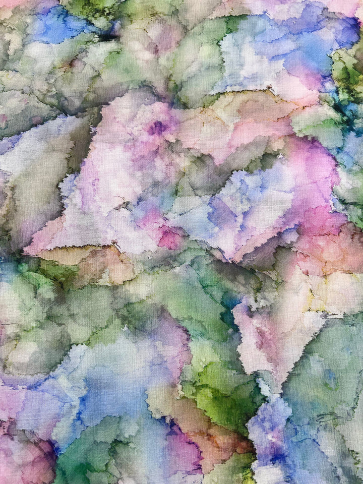 The Designer Cotton - Pastel - 150cm from Super Cheap Fabrics evokes luxury with its colorful abstract hues of green, pink, blue, and purple blending organically like a watercolor painting, creating a soft, cloud-like texture.