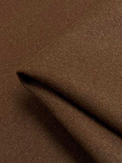 Close-up of a folded piece of Wool Cashmere - Brown - 150cm from Super Cheap Fabrics, showcasing its soft texture. The fabric appears to have a smooth and matte finish, with the edge of the fold slightly visible in the upper part of the image.