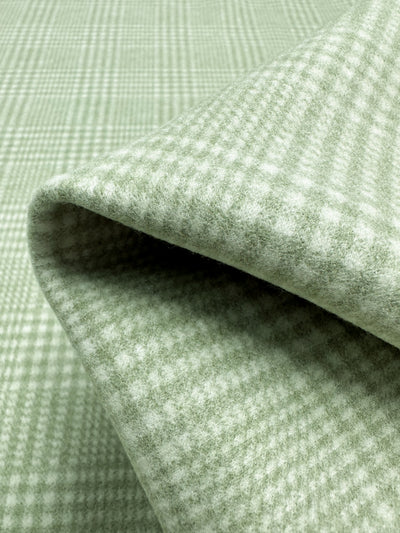 Close-up of folded Wool Flannel - Sage by Super Cheap Fabrics, featuring heavyweight green plaid wool with soft texture. The pattern includes sage and light green checks for a subtle classic design. Width: 148cm.