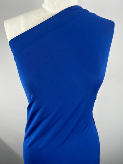 A mannequin presents a vibrant Snorkel Blue, off-the-shoulder dress crafted from Plain Lycra - Snorkel Blue - 150cm by Super Cheap Fabrics. This smooth and form-fitting fabric elegantly drapes over the mannequin's frame against a plain background.