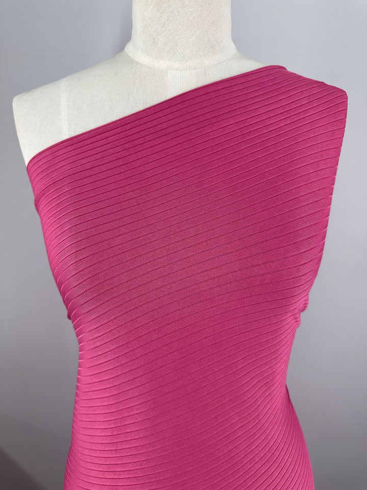 A mannequin displays a Super Cheap Fabrics' Rib Knit dress in Lilac Rose, featuring a stretchy, comfortable, one-shoulder fitted style against a plain background.