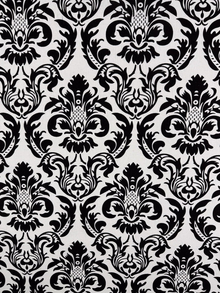 Super Cheap Fabrics' Printed Linen Blend - Baroque Noir (145cm) features an ornate black and white damask floral design on soft cotton linen, creating a classic, elegant look ideal for stylish summer jackets.
