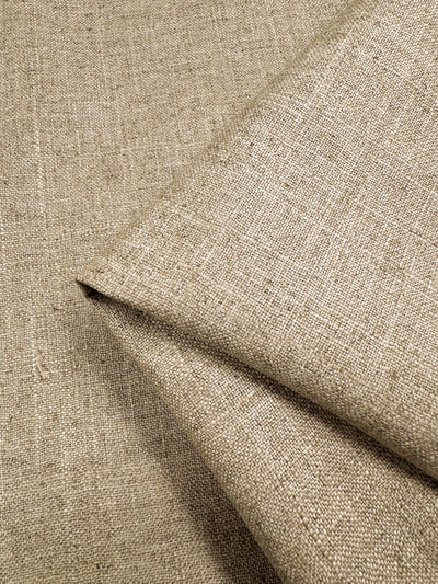 Close-up of the heavy-weight, Biscotti-toned Linen Viscose - 144cm by Super Cheap Fabrics reveals its slightly coarse weave, perfect for upholstery. The plain fabric rests on a matching background, highlighting its natural texture and simple design.
