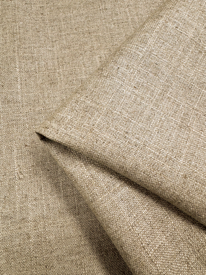Close-up of the heavy-weight, Biscotti-toned Linen Viscose - 144cm by Super Cheap Fabrics reveals its slightly coarse weave, perfect for upholstery. The plain fabric rests on a matching background, highlighting its natural texture and simple design.