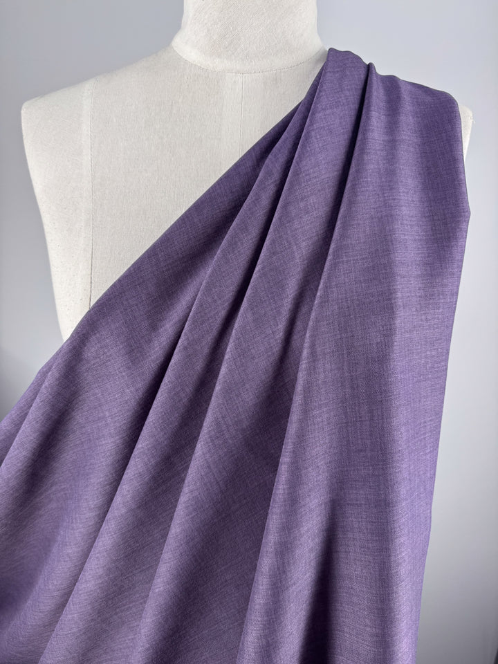 A white dress form draped with Super Cheap Fabrics’ Twill Suiting - Wineberry - 150cm showcases the fabric’s soft texture, versatile use, and subtle diagonal weave against a plain background.