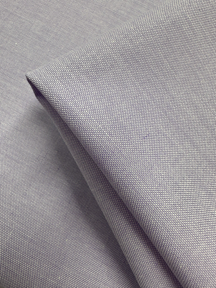 Close-up of folded Oxford Cotton in Baby Lavender (146cm) by Super Cheap Fabrics. The fine, tightly woven cotton appears smooth and slightly reflective with neat folds and clean edges.