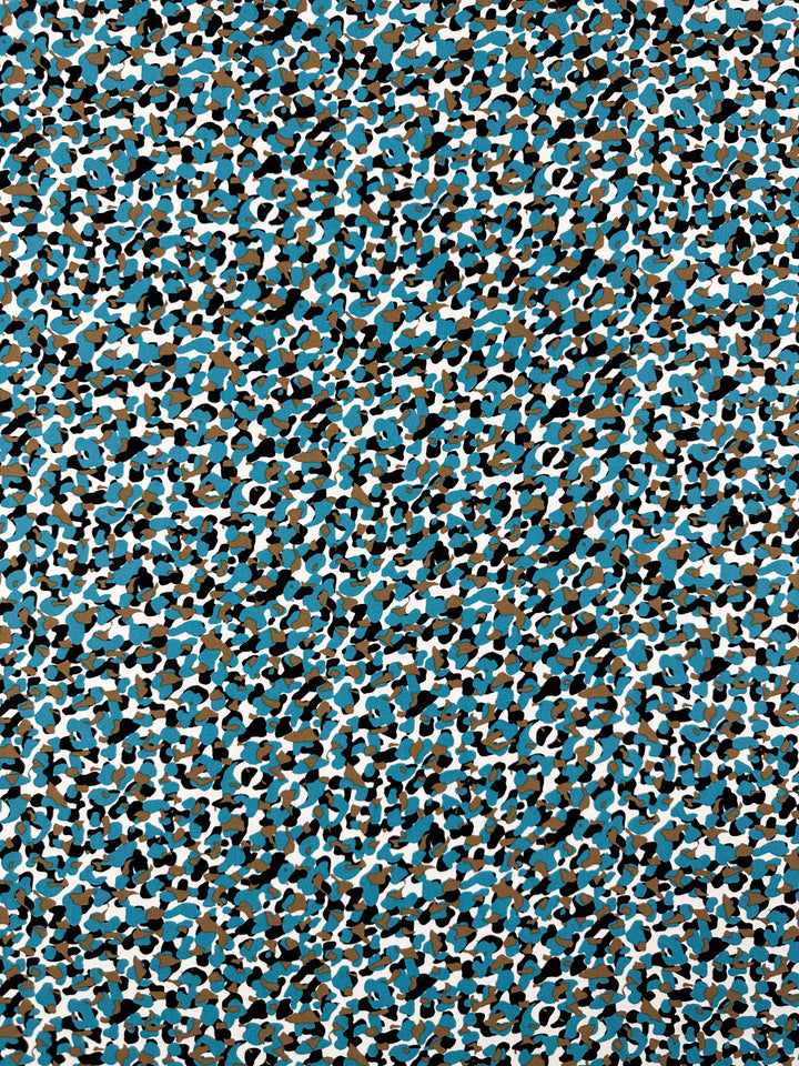 Discover the "Viscose Crepe - Stoney - 150cm" by Super Cheap Fabrics, showcasing an intricate abstract design with blue, black, white, and brown camouflage in a mix of shapes and sizes. Perfect for crafting exquisite Viscose Crepe pieces that turn versatile clothing into artistic expressions.