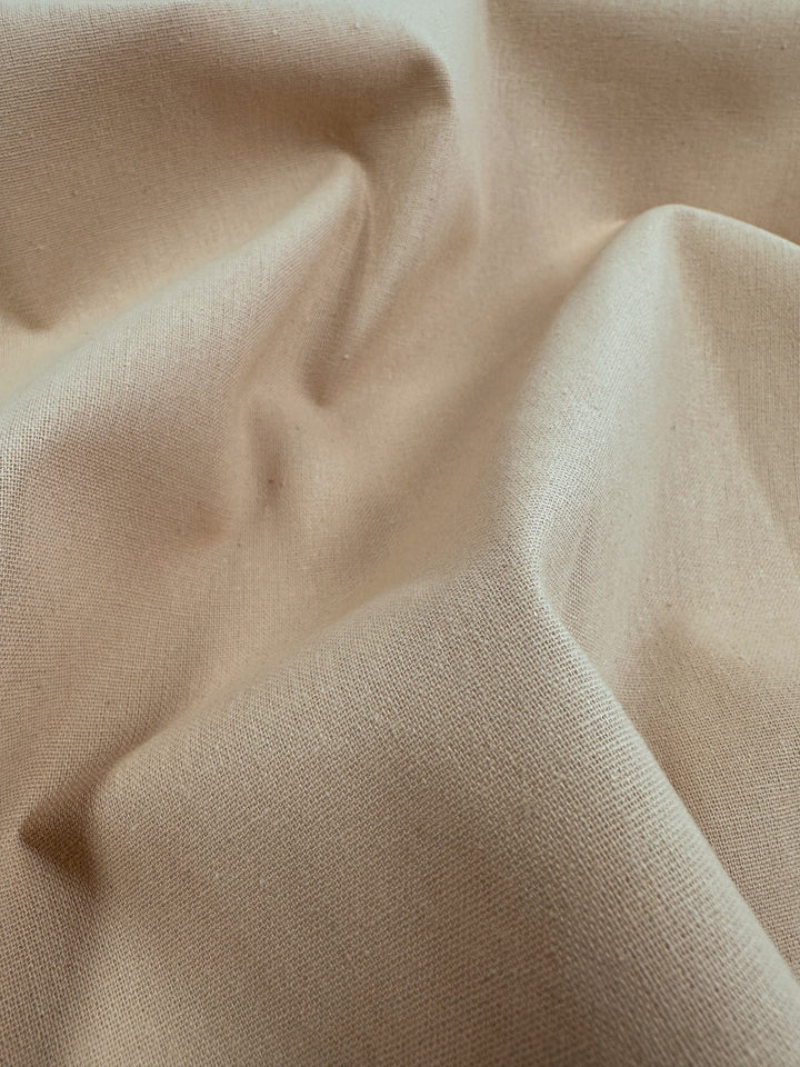 A close-up of Super Cheap Fabrics' Ramie Linen in Hazelnut showcases its soft, textured surface with gentle wrinkles and folds, emphasizing the fabric's flexibility and tactile quality characteristic of natural fibers.