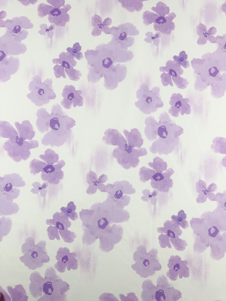 The Bellflower printed cotton fabric by Super Cheap Fabrics features a delicate design of light purple watercolor flowers on a white background, making it an ideal choice for enhancing your home decor.