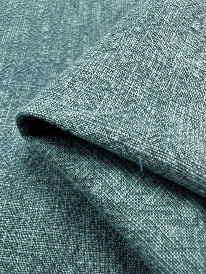 Close-up of folded Basket Dyed Cotton in Peacock, crafted by Super Cheap Fabrics, featuring a textured surface with twill weave details visible and a soft, slightly wrinkled appearance.