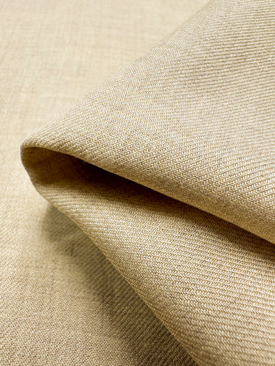 Close-up of the folded Linen Blend - Banana Crepe fabric from Super Cheap Fabrics, highlighting its textured woven pattern. This 142cm lightweight material appears soft and smooth with a subtle sheen, showcasing its quality and natural beige color.