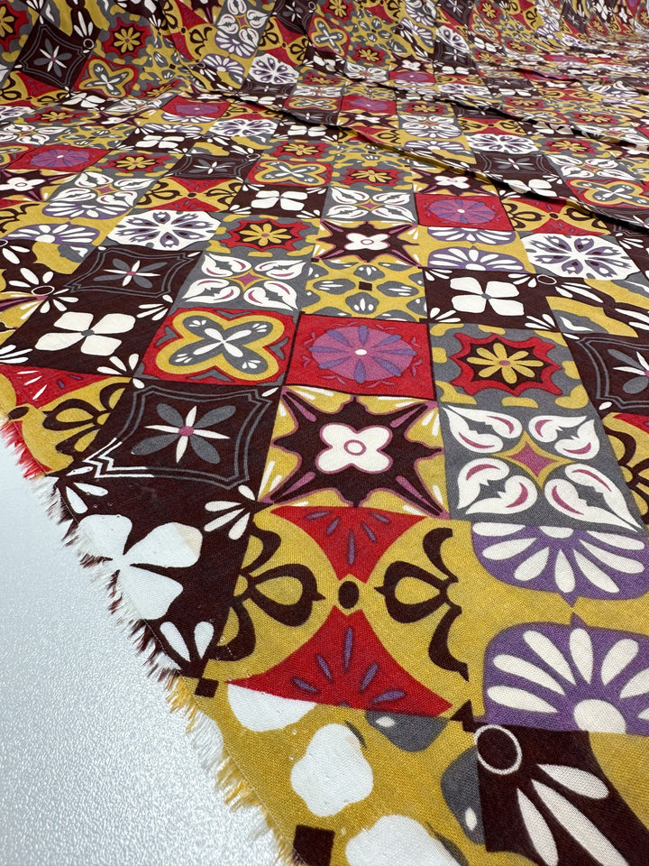 The "Linen Blend - Mosaic - 145cm" by Super Cheap Fabrics is a lively and breathable fabric featuring a patchwork of colorful geometric designs in shades of red, yellow, black, white, and brown. It showcases lightweight patterns with floral and abstract shapes for a dynamic appearance.