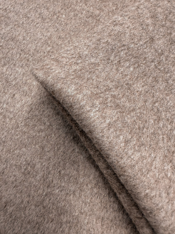 A close-up of Super Cheap Fabrics' Wool Cashmere - Peyote Marle (152cm), highlighting its soft, heavyweight wool-blend in light brown with a fuzzy texture and overlapping folded edges.