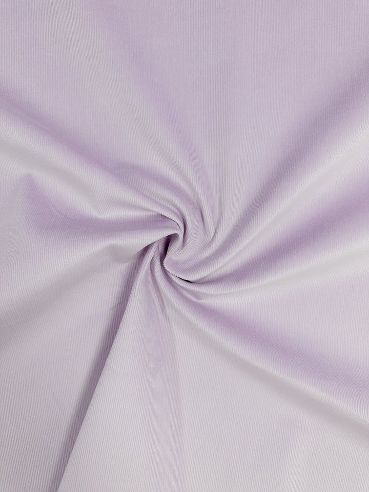 The Micro Wale Corduroy in Lavender Frost by Super Cheap Fabrics, 145cm wide, features a smooth, soft texture with gentle folds creating a circular pattern. Its delicate corduroy appearance and slightly shiny finish make it ideal for winter clothing.