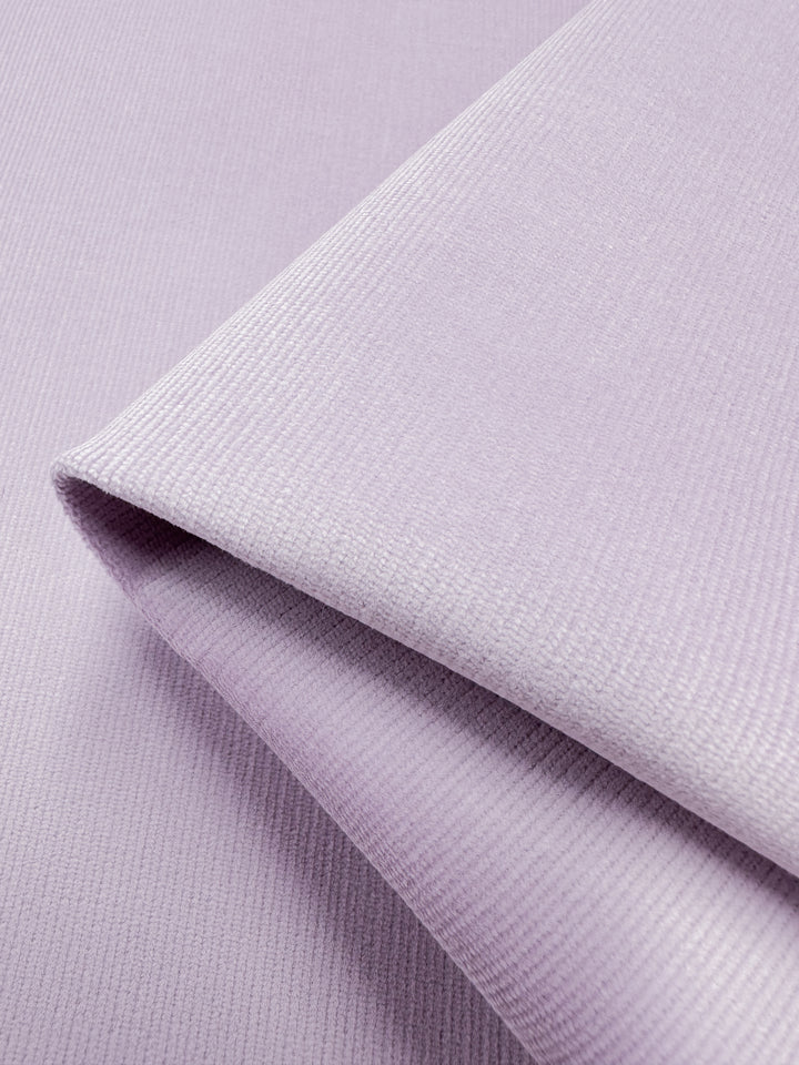 Close-up of the soft, ribbed texture of Super Cheap Fabrics' Micro Wale Corduroy in Lavender Frost, 145cm, with a subtle sheen, neatly folded against a matching background.