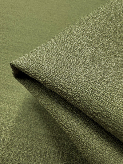 Close-up image of a folded piece of textured fabric from Super Cheap Fabrics, featuring a fine grid-like pattern. This lightweight Cedar 150cm suiting fabric is soft yet slightly rough, showcasing intricate weaving details ideal for crafting elegant formal suits.