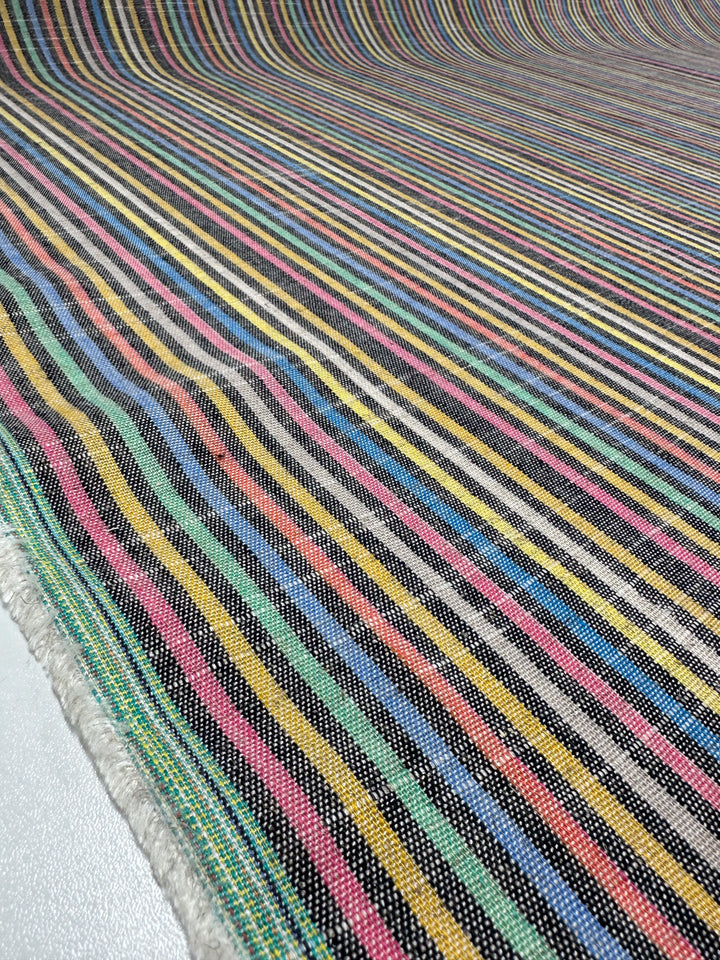 A close-up of the Linen Blend - Beachside - 143cm from Super Cheap Fabrics shows a medium-weight, vintage-look fabric with colorful horizontal stripes in blue, green, yellow, pink, and black for a vibrant texture.