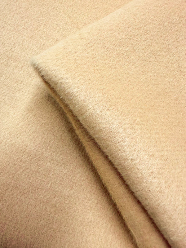 Close-up of Wool Cashmere - Banana Crepe - 150cm by Super Cheap Fabrics, showing its folded beige surface with a soft, slightly fuzzy texture that highlights the thickness and luxurious feel of this heavyweight wool cashmere fabric.