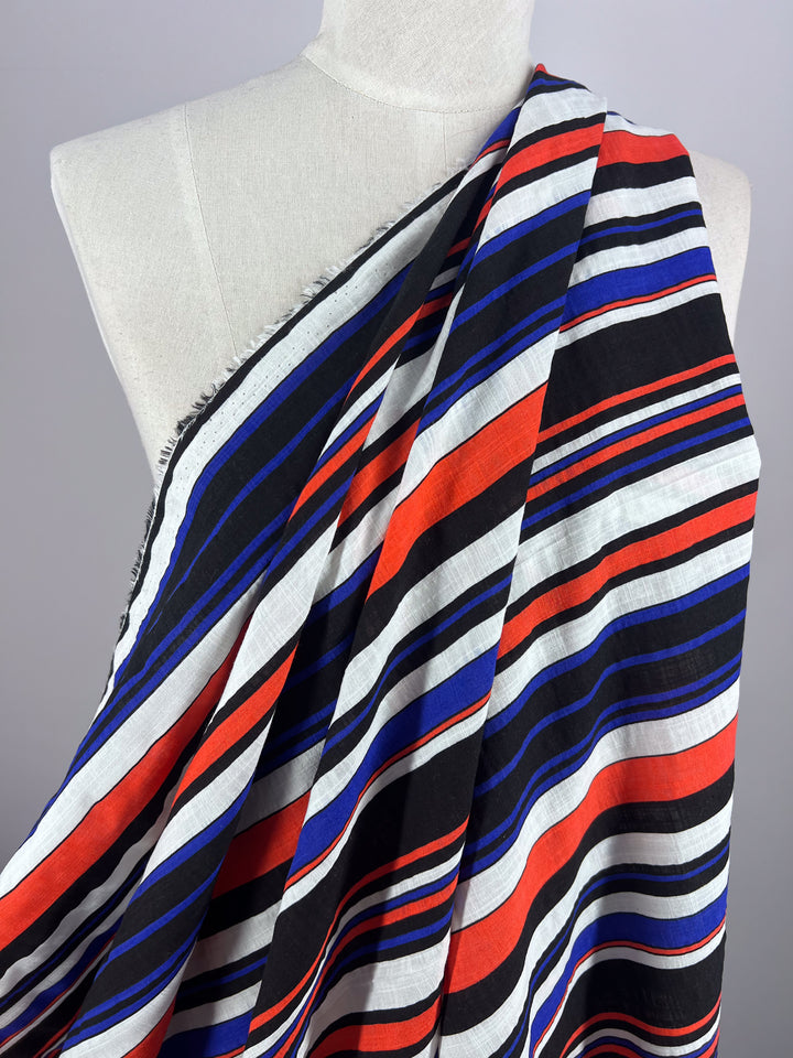 A mannequin covered with Super Cheap Fabrics' Linen Blend - Minimal fabric, featuring horizontal stripes in black, white, red, and blue on a light background.