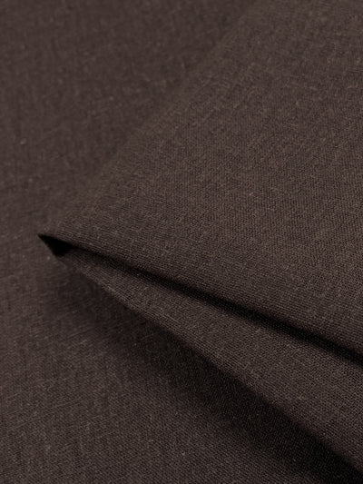 A close-up of the Premium Linen Cotton in a Rocky Road color by Super Cheap Fabrics showcases its smooth texture, slightly folded at one corner. The textile's tight weave and thickness suggest high quality, making it ideal for garments or upholstery.