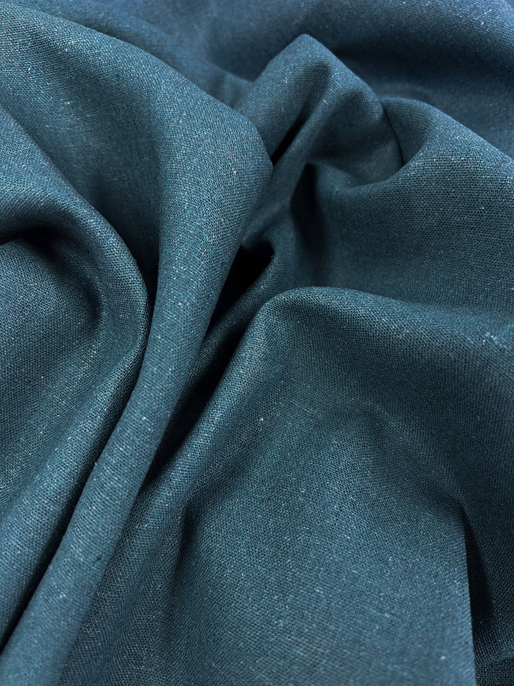 A detailed view of the Premium Linen Cotton in balsam from Super Cheap Fabrics showcases its rich color and subtle texture, forming soft folds and delicate creases. This lightweight fabric beautifully captures light and shadow, enhancing its smooth appearance.