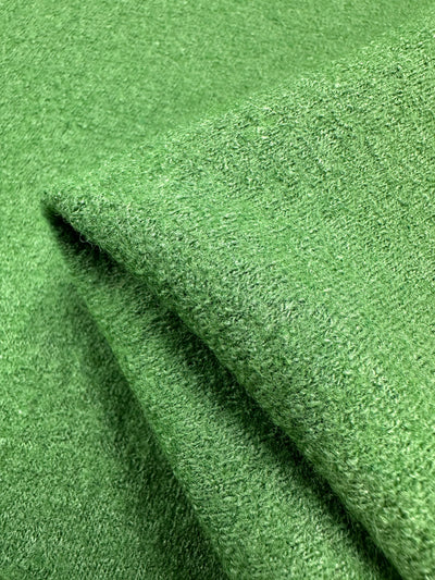 Close-up of Boiled Wool - Meadow Green by Super Cheap Fabrics, a 145cm folded fabric crafted from a rich wool-viscose blend with a soft, textured surface that exudes coziness.