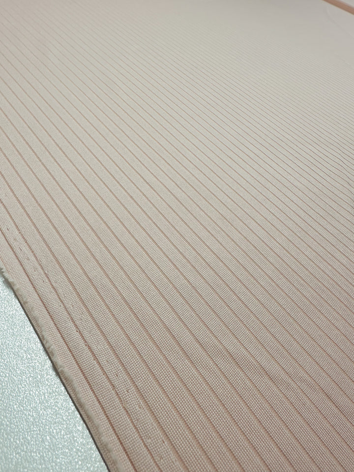 Close-up of Super Cheap Fabrics' medium rib knit in Creole Pink, 168cm. The fabric has diagonal, evenly spaced, slightly raised lines and a smooth, stretchy surface.