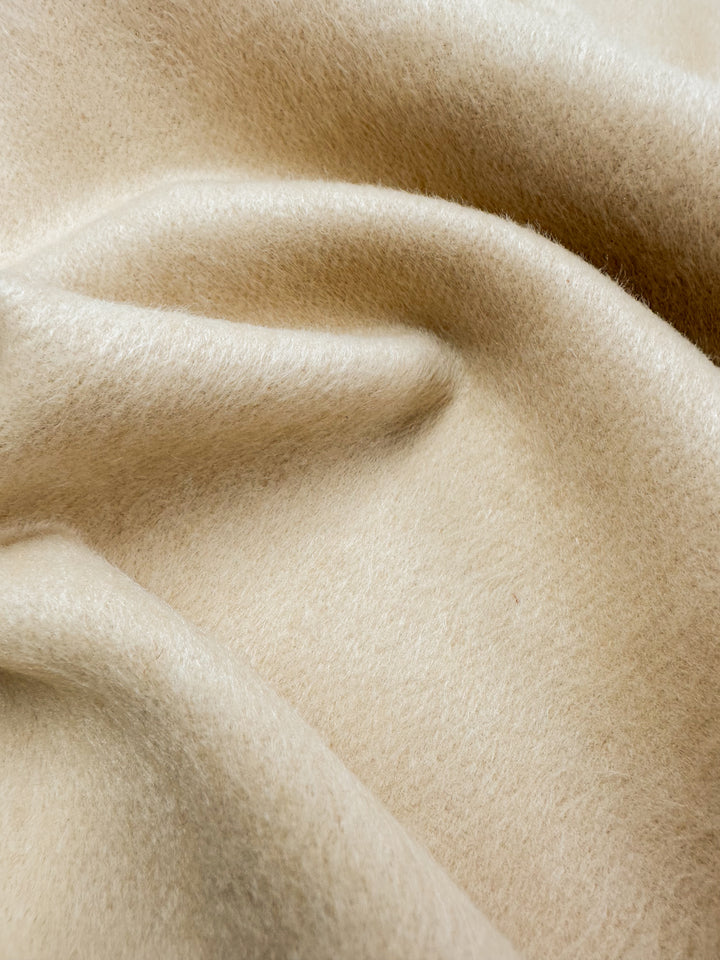 Close-up of the Wool Cashmere fabric in Gray Sand from Super Cheap Fabrics. With a soft, fuzzy texture, it drapes smoothly, exuding elegance and luxurious warmth for ultimate comfort.