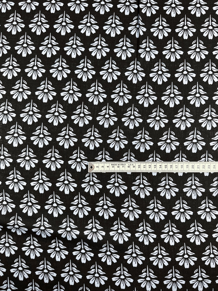 The Linen Blend - Chambray Floretta by Super Cheap Fabrics, a black linen cotton blend with a white floral pattern, is shown with a measuring tape in centimeters.