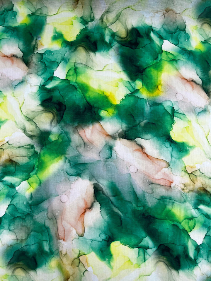 The Designer Cotton - Fern - 150cm by Super Cheap Fabrics boasts flowing shades of green, yellow, with hints of pink and brown. The seamless blending of colors creates a marbled effect with soft edges and subtle gradients, perfect for inspiring luxury sewing projects.