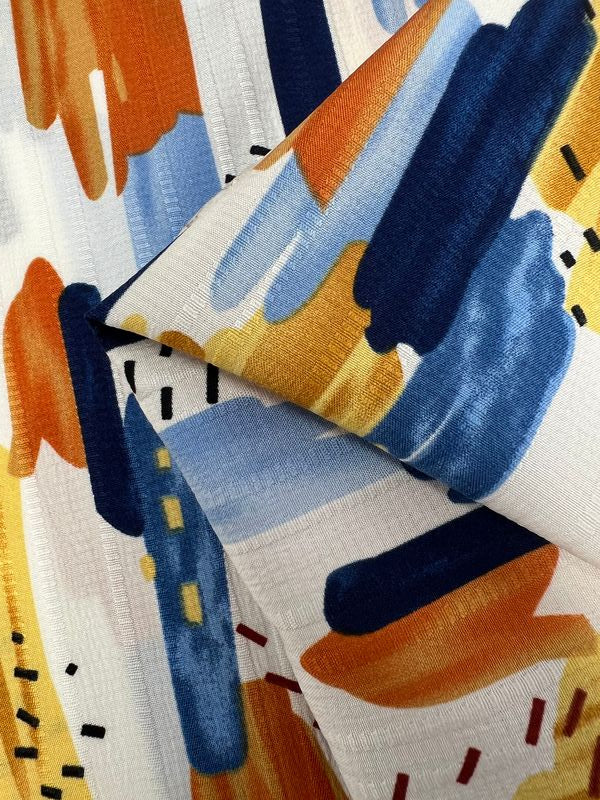 Experience the vibrant Textured Deluxe Print - Stroke & Speck 1.0 by Super Cheap Fabrics, showcasing expressive brushstrokes in orange, blue, yellow, and black on a white backdrop. This dynamic designer fabric pattern features scattered dotted lines for a colorful and versatile design that's perfect for various fabric applications. Available in a 155cm width.