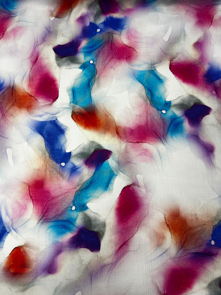 Introducing the Designer Cotton - Crysta - 150cm from Super Cheap Fabrics, this fabric showcases stunning swirling patterns in vibrant hues of blue, red, purple, and orange against a white backdrop. The fluid blending of colors creates a dynamic and lively visual effect that is perfect for inspiring elegant sewing projects.